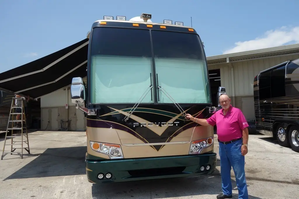 A happy Excalibur Coach client beside their 1999 Prevost H3-45 Featherlite after its 2016 facelift